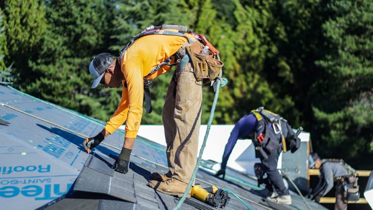 A Cherry Roofing Crew member laying shingles on a new roof.